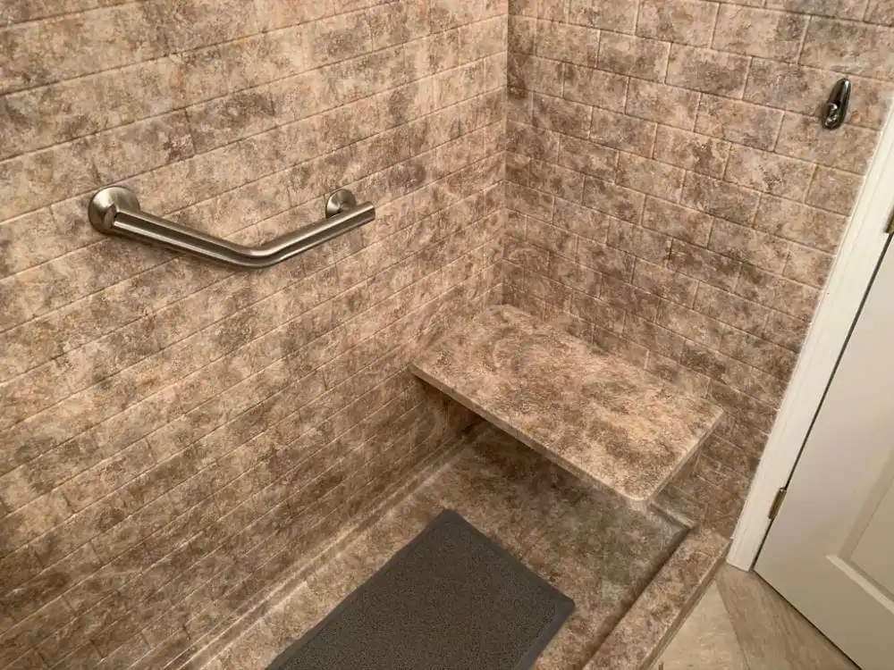 accessible marble shower with grab bar, shower seat, and slip resistant mat