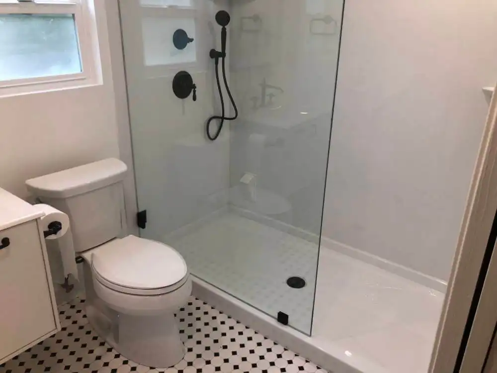 walk in shower installation with black shower head and accessories