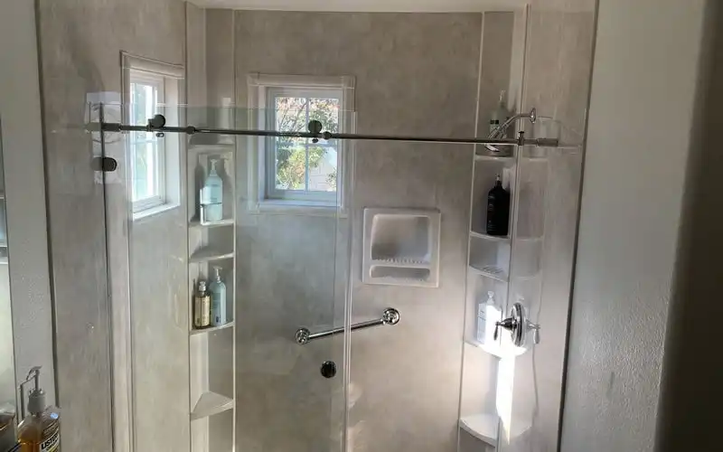 shower with glass shower doors and two small windows